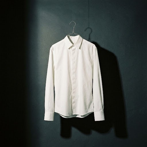 White poplin shirt suspended on a wire hanger